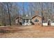 View of a stone accented home with a welcoming front yard and charming white picket fence and arbor at 332 Stonecutters Cv, Stockbridge, GA 30281