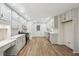 Modern eat-in kitchen featuring white cabinets, stainless steel appliances, wood floors, and a built-in desk at 332 Stonecutters Cv, Stockbridge, GA 30281