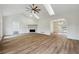 Bright living room with vaulted ceilings, skylights, a modern ceiling fan, fireplace, and hardwood floors at 332 Stonecutters Cv, Stockbridge, GA 30281