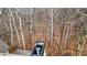 Backyard view of a wooded lot with bare trees and dried leaves with the top of the chimney in the foreground at 492 Broadstone Nw Way, Acworth, GA 30101