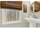 Bathroom features a pedestal sink, gold mirror, and natural light at 492 Broadstone Nw Way, Acworth, GA 30101