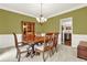 Elegant dining room with a wooden table and chairs, decorative chandelier, and olive green walls creating a warm and inviting space at 492 Broadstone Nw Way, Acworth, GA 30101