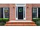 Close up of a beautiful brick home's entryway, featuring a black door with a wreath and sidelights at 492 Broadstone Nw Way, Acworth, GA 30101