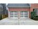 Spacious two-car garage with modern doors and a well-maintained driveway, nestled in a wooded neighborhood at 492 Broadstone Nw Way, Acworth, GA 30101