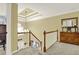 Bright hallway features a decorative ceiling, wooden railing, and views to the lower level, creating an open and airy feel at 492 Broadstone Nw Way, Acworth, GA 30101