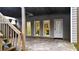 Covered patio with concrete floor and gray siding walls showcases stairs leading up to a raised deck with exterior lighting and a fan at 492 Broadstone Nw Way, Acworth, GA 30101