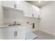 Functional laundry room equipped with white cabinets, sink, and tile flooring at 5238 Timber Ridge Rd, Marietta, GA 30068