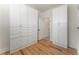 Walk-in closet with custom white cabinets and drawers and hardwood floors at 5238 Timber Ridge Rd, Marietta, GA 30068