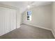 Cozy bedroom with plush carpet, a large window, a ceiling fan, and a closet for ample storage at 1740 Berry Ct, Cumming, GA 30041