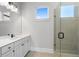 Bathroom featuring walk-in shower with glass door, tiled floors, and double sink vanity with light fixtures at 320 Gray Shingle Ln, Woodstock, GA 30189