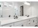 Bright bathroom featuring double sinks, a large mirror, and a tiled shower with modern fixtures at 320 Gray Shingle Ln, Woodstock, GA 30189