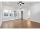 Bright bedroom with a ceiling fan, three windows, and hardwood floors, adjacent to a full bathroom at 320 Gray Shingle Ln, Woodstock, GA 30189