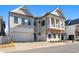 Beautiful two-story home featuring a brick driveway, covered porch, attached garage, and professionally landscaped front yard at 320 Gray Shingle Ln, Woodstock, GA 30189