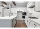 Bright and open kitchen with white cabinets, stainless steel appliances, a gray island, and hardwood flooring at 320 Gray Shingle Ln, Woodstock, GA 30189