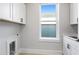 Laundry room with white cabinets and a window at 320 Gray Shingle Ln, Woodstock, GA 30189