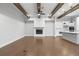 Spacious living room with hardwood floors, wood beams, fireplace, and a view of the modern, bright kitchen at 320 Gray Shingle Ln, Woodstock, GA 30189