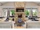 Bright living room with stone fireplace and large windows overlooking the pool at 320 Gray Shingle Ln, Woodstock, GA 30189