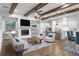 Bright, open-concept living room featuring hardwood floors, beamed ceilings, and a modern fireplace at 320 Gray Shingle Ln, Woodstock, GA 30189