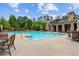 Community pool with lounge chairs surrounded by green landscaping on a sunny day at 320 Gray Shingle Ln, Woodstock, GA 30189