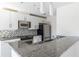 Well-lit kitchen featuring granite countertops, stainless steel appliances, and modern white cabinetry at 335 W Ponce De Leon Ave # 506, Decatur, GA 30030