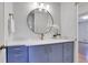 Stylish bathroom vanity with blue cabinets, white countertop, round mirror, and gold fixtures at 4169 Cedar Valley Ln, Conley, GA 30288