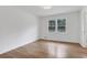 A light filled bedroom showcasing beautiful hardwood flooring, fresh paint, and a great window view at 4169 Cedar Valley Ln, Conley, GA 30288