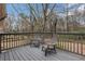 Relax on the deck featuring two chairs and a wooden railing, overlooking the beautiful trees and landscaping at 4169 Cedar Valley Ln, Conley, GA 30288