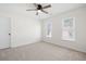 Neutral bedroom features a ceiling fan, carpet, and two windows with bright light at 2038 Cresthaven Walk, Woodstock, GA 30189