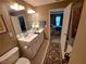 Bathroom featuring double sink vanity, tiled floors, and a connecting door to the bedroom at 215 Kigian Trl, Woodstock, GA 30188