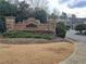 Elegant stone signage marks the entrance to the community, enhanced with lush landscaping at 215 Kigian Trl, Woodstock, GA 30188