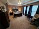 Main bedroom with ceiling fan, tray ceiling, carpet, and a comfortable rocking chair at 215 Kigian Trl, Woodstock, GA 30188