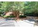 Classic brick building entrance with mature trees, landscaping, and convenient parking at 25309 Plantation Ne Dr # 309, Atlanta, GA 30324