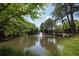 Scenic view of a pond with a fountain surrounded by lush greenery at 25309 Plantation Ne Dr # 309, Atlanta, GA 30324