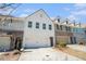 Beautiful townhouse with a two-car garage and white brick facade under a clear blue sky at 2978 Edgemont Ln, Marietta, GA 30008