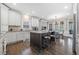 Bright eat-in kitchen features an island with bar seating, granite countertops, white cabinets, and hardwood floors at 9795 Terrace Lake Pointe, Roswell, GA 30076