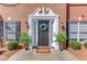 Elegant front entrance featuring a black door with decorative wreath, flanked by small trees at 2678 Stockbridge Way, Dacula, GA 30019