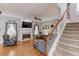 Open living room with fireplace, stairs, hardwood floors, and natural light at 2678 Stockbridge Way, Dacula, GA 30019