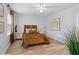 Bedroom with wood floors and tan striped comforter, neutral wall art and a bright window at 5273 Glenridge Dr # 5273, Sandy Springs, GA 30342