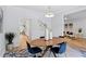 Bright dining room features a modern chandelier, blue chairs, and an open layout to other rooms at 5273 Glenridge Dr # 5273, Sandy Springs, GA 30342