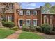 Charming brick townhouse with black shutters, manicured lawn, and blooming tree at 5273 Glenridge Dr # 5273, Sandy Springs, GA 30342