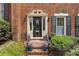 Elegant brick home entrance with decorative door surround and well-manicured landscaping at 5273 Glenridge Dr # 5273, Sandy Springs, GA 30342