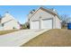 Exterior view of home featuring a two-car garage and long driveway at 7282 Williamsburg Dr, Riverdale, GA 30274