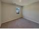 Carpeted bedroom with neutral walls, bright window with views of nature, and ample space for versatile furnishing at 8120 Berrywood Ct, Covington, GA 30014
