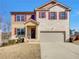 Charming two-story home featuring a brick and tan facade, attached two-car garage, and manicured landscaping at 8120 Berrywood Ct, Covington, GA 30014