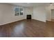 Spacious living room with a fireplace, large windows for ample natural light, and sleek hardwood flooring at 8120 Berrywood Ct, Covington, GA 30014