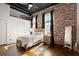 Charming bedroom with exposed brick wall, hardwood floors, and modern ceiling fan at 1459 Village Park Ct, Atlanta, GA 30319