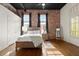 Inviting bedroom featuring exposed brick wall, a queen bed, and natural light at 1459 Village Park Ct, Atlanta, GA 30319