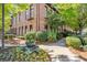 Beautiful red brick exterior with black framed windows and balcony surrounded by trees and bushes at 1459 Village Park Ct, Atlanta, GA 30319