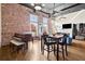 Bright, open living room with brick wall, high ceilings, hardwood floors, and piano at 1459 Village Park Ct, Atlanta, GA 30319