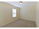 A bright bedroom with neutral carpeting features a window bringing in natural light at 1614 Carrie Farm Ct, Kennesaw, GA 30144